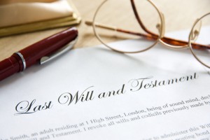 A will and testament with glasses, pen and wallet.