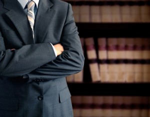 A man in suit and tie standing with his arms crossed.