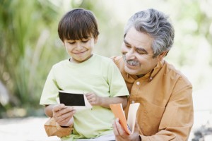A man and boy looking at an electronic device.